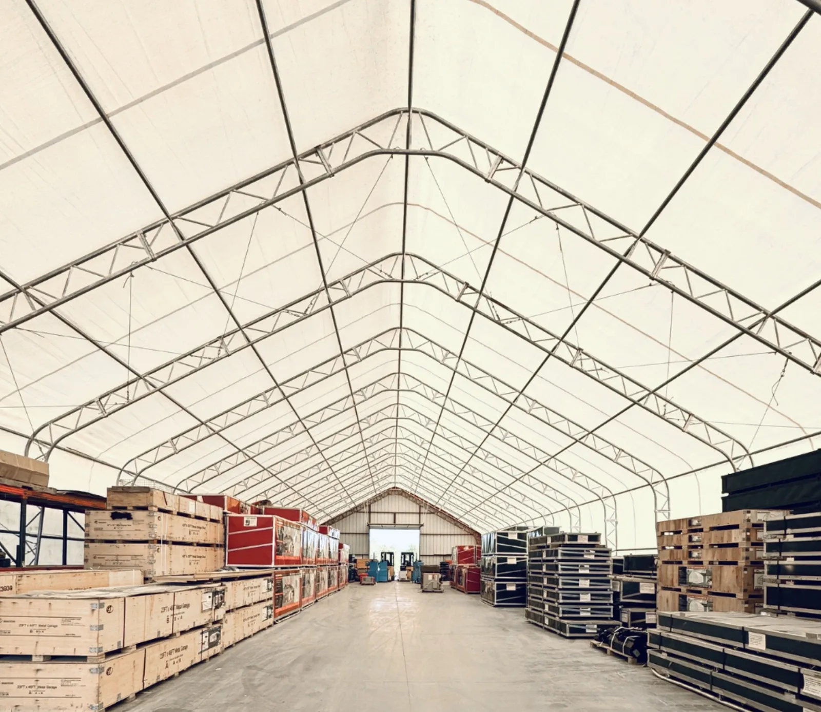 Inside Covermore's 50x150 dual truss fabric warehouse, stacked with building kits